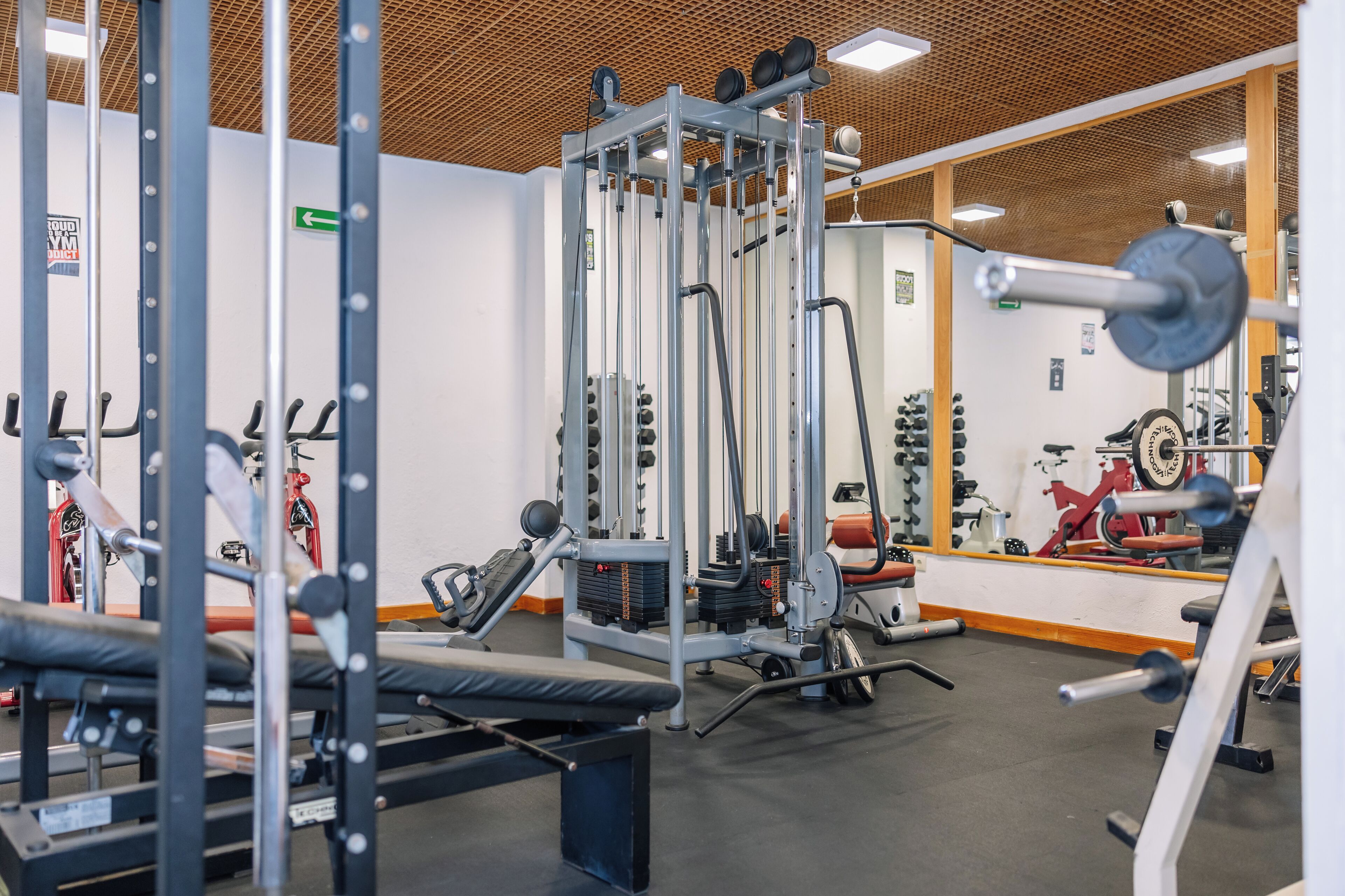 Un gimnasio con diversos equipos de ejercicio, que incluyen máquinas de pesas y pesas libres.