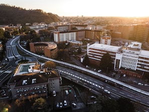 Vista aérea de un paisaje urbano con una autopista, edificios y un fondo montañoso.