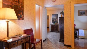 Une pièce comprenant un bureau, une chaise, une lampe et un tableau accroché au mur.
