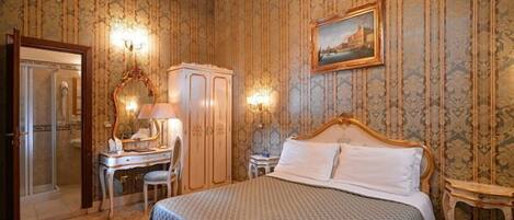 Une chambre avec un lit, un bureau, une armoire et un miroir.