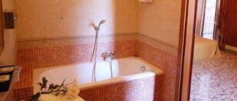 Un bany amb banyera, un lavabo i plat de dutxa.