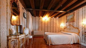Une chambre comprenant un lit, une coiffeuse avec un miroir, une chaise et un radiateur fixé au mur.