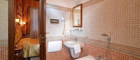 A bathroom with a bathtub, sink, and towel rack.