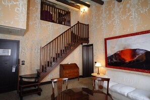 A room with a staircase, wooden furniture, a white sofa, and a painting. - Bauer Casa Nova (VENECIA)