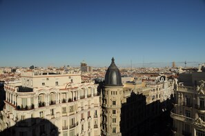 A cityscape with historic buildings, including a prominent building with a dome and another with a tower. - Hostal Luis XV (Madrid)