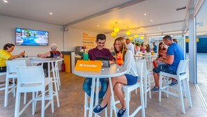 A cafe with white wicker chairs and tables, a TV mounted on the wall, and a sign for ConnectBar. - Kipriotis Aqualand by Anayia All Inclusive Resorts (Kos)