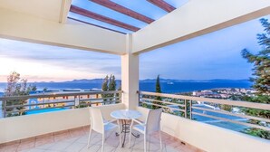 A balcony with a table and chairs, overlooking a coastal view with buildings and a body of water. - Kipriotis Aqualand by Anayia All Inclusive Resorts (Kos)