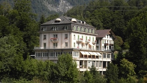Un hôtel à plusieurs étages, doté de balcons et offrant une vue sur un paysage montagneux.