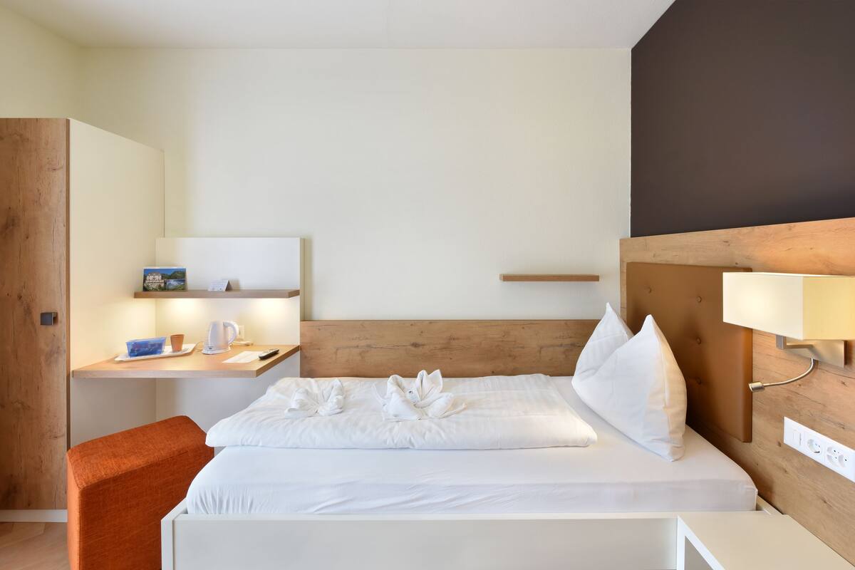 Une chambre d’hôtel comprenant un lit, un bureau, une chaise et une table de chevet.