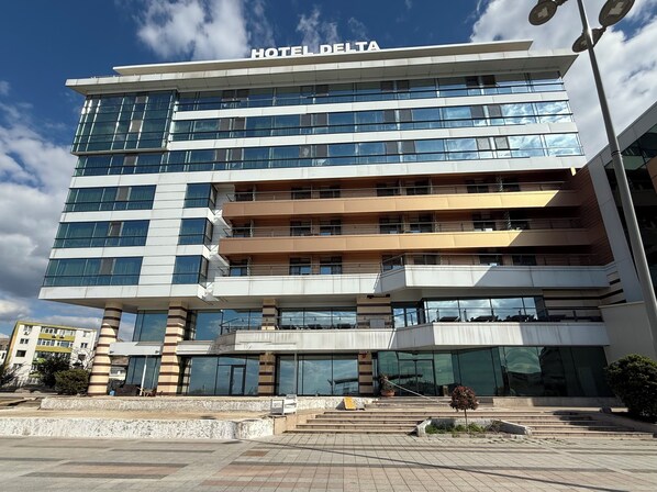 A multi-story hotel with a modern design, featuring large windows and a prominent 'HOTEL DELTA' sign.