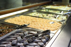 A buffet with various food items, including fish, salads, and other dishes.