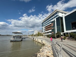 A waterfront hotel with a modern design, a dock, and a pedestrian walkway.