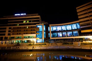 A modern hotel with a prominent 'HOTEL DELTA' sign, featuring a glass facade and a waterfront location. - Delta 4 (Tulcea)