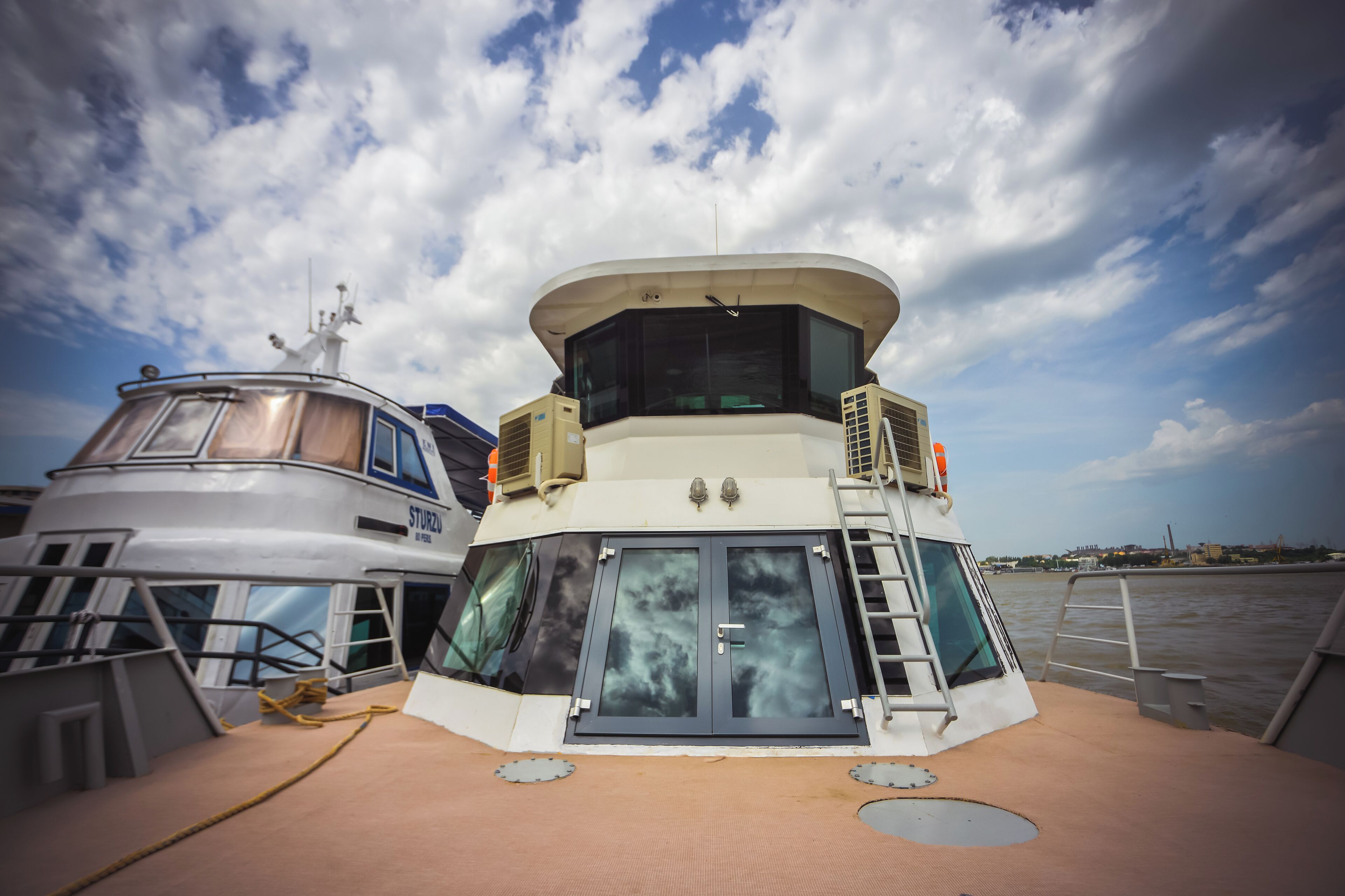 A boat with a control tower, a lifeboat, and a ladder.