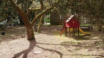Children can play in the outdoor area with a playhouse and slide.
