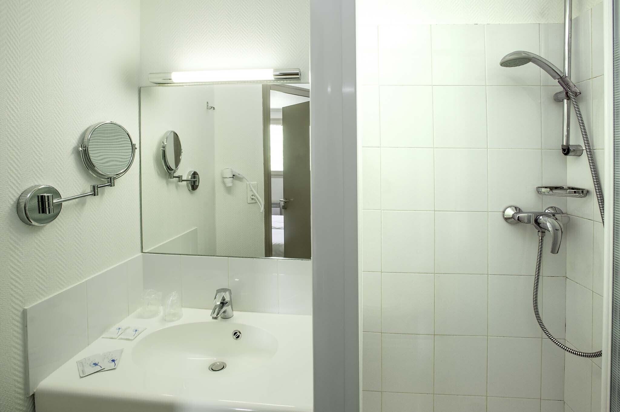 Une salle de bain avec un lavabo, un miroir et une douche.