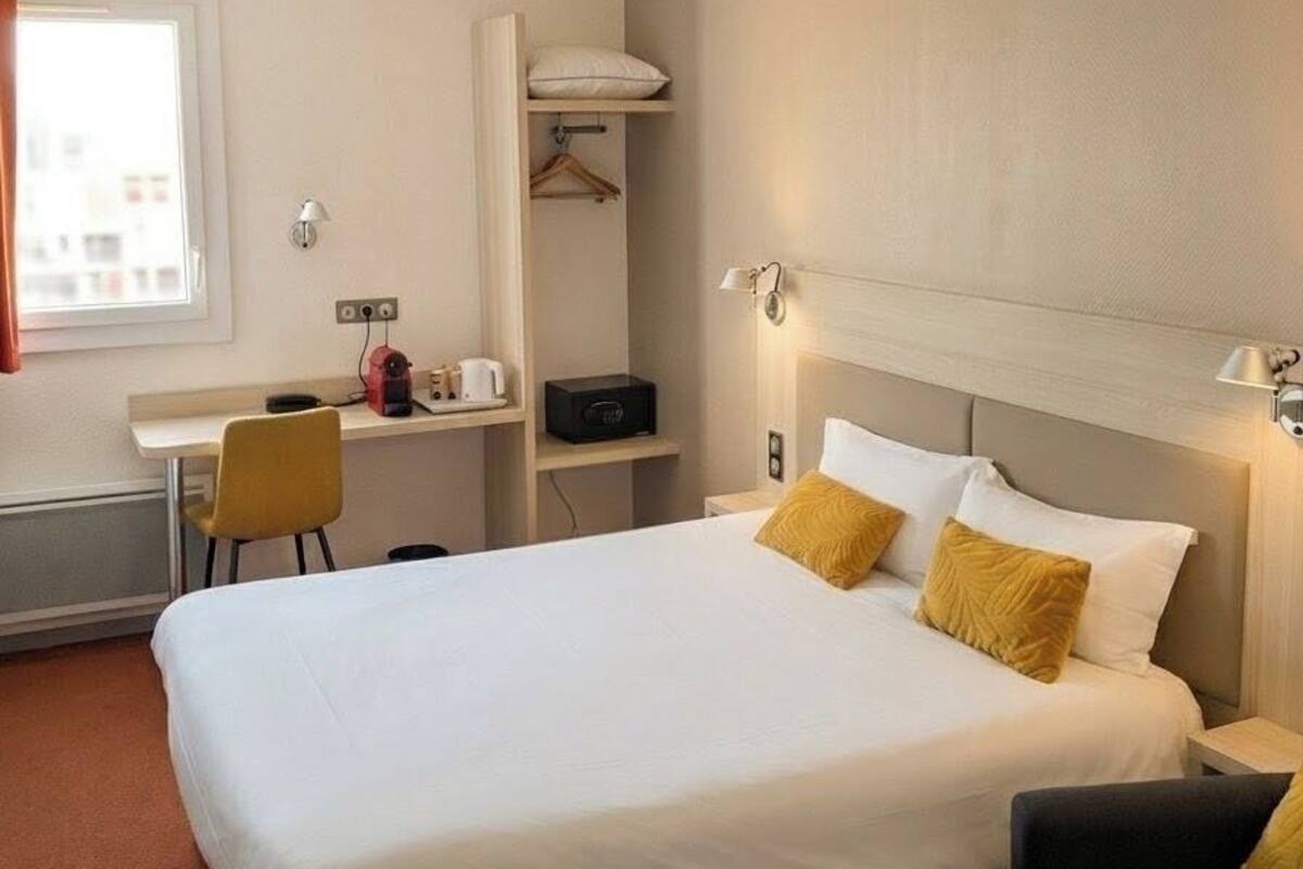 Ein Hotelzimmer mit einem Bett, einem Schreibtisch, einem Sessel und einer Couch.