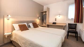 Een hotelkamer met een groot bed, nachtkastjes, een bureau en een stoel.