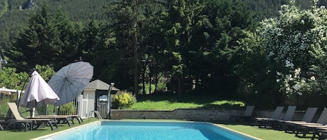 Alberca al aire libre por temporada y sombrillas en la alberca