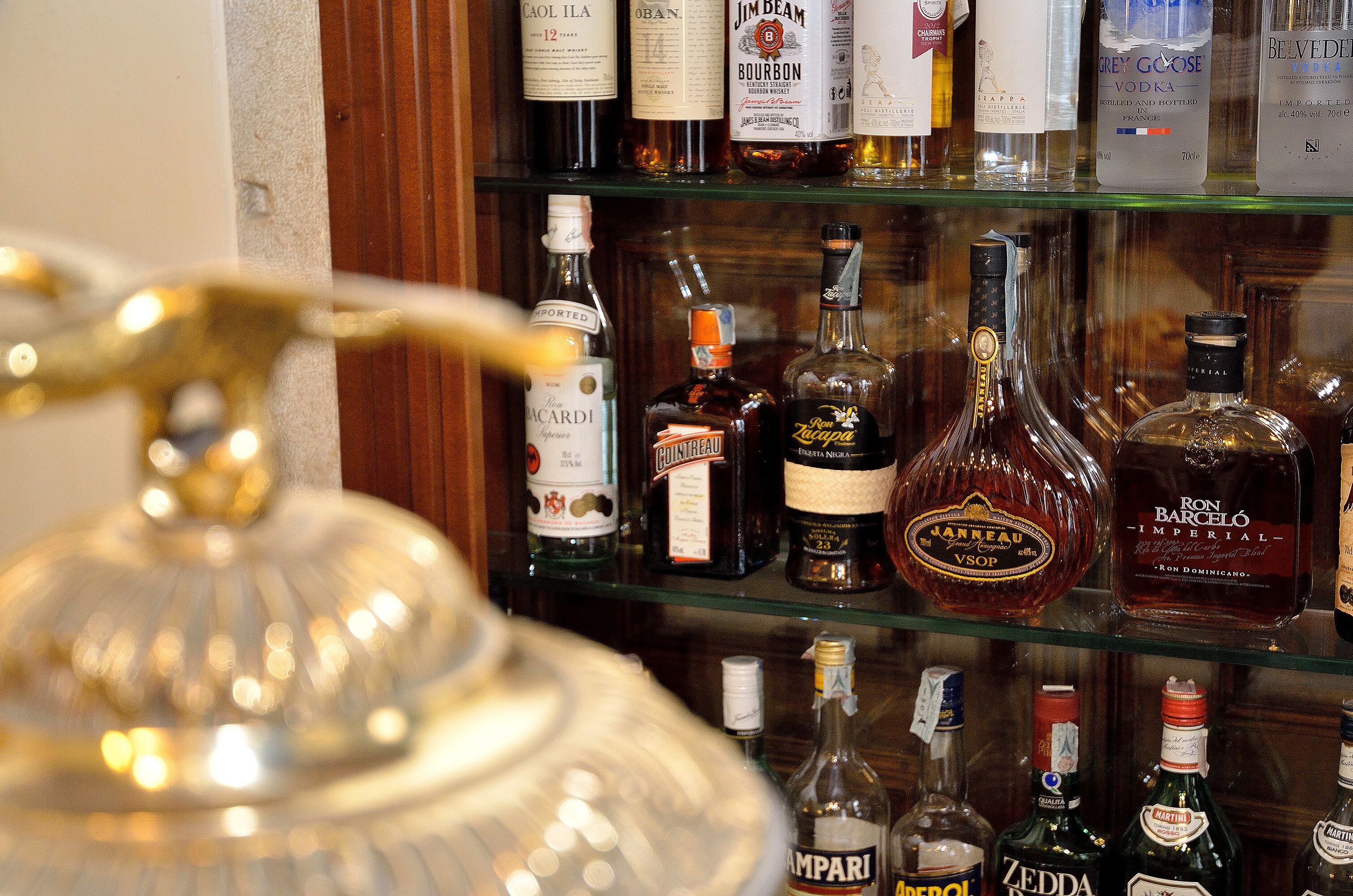 Variedad de botellas de licores en estantes.