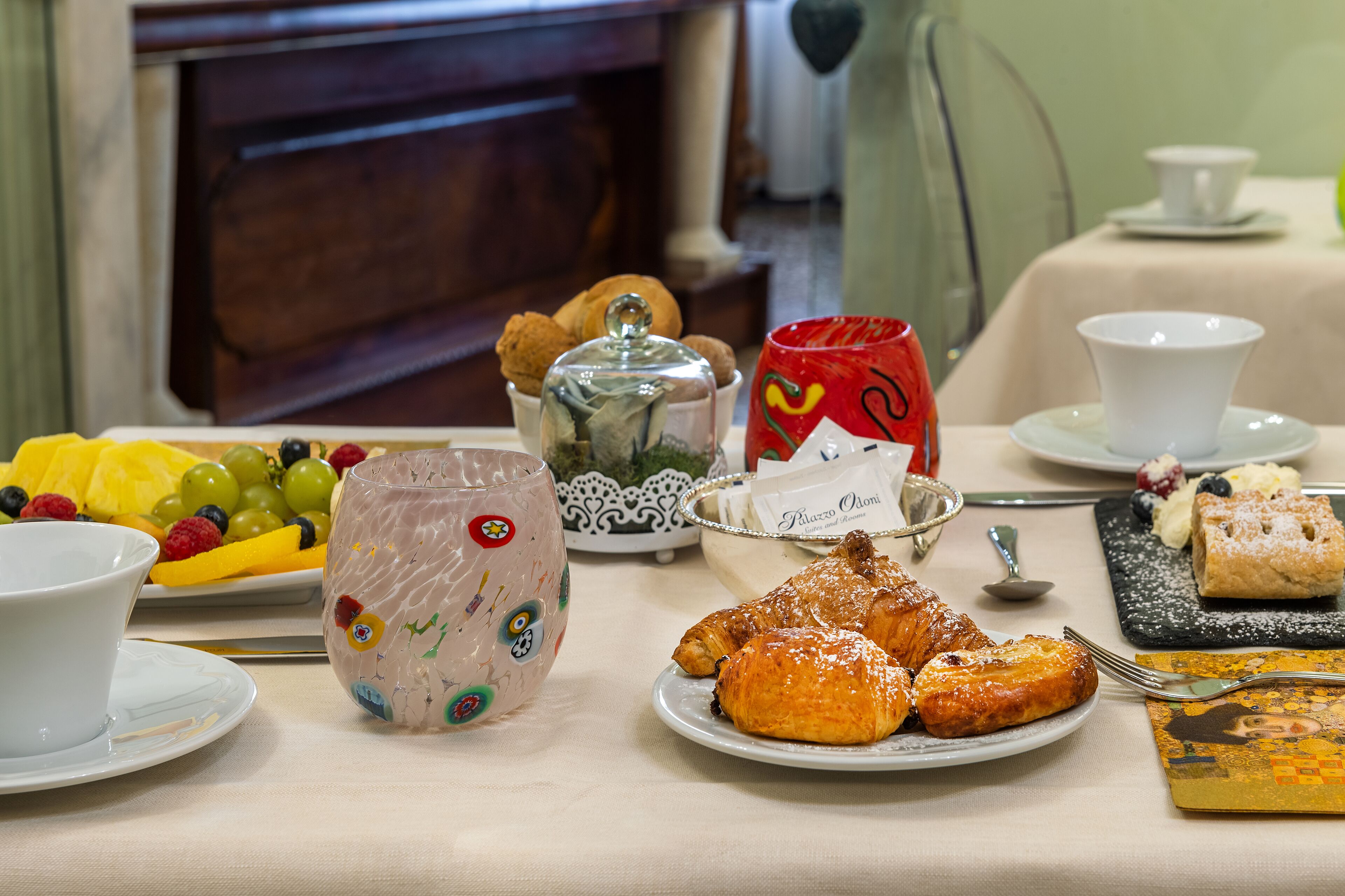 Taula de l'esmorzar amb pastissos, fruita i una tassa de cafè.