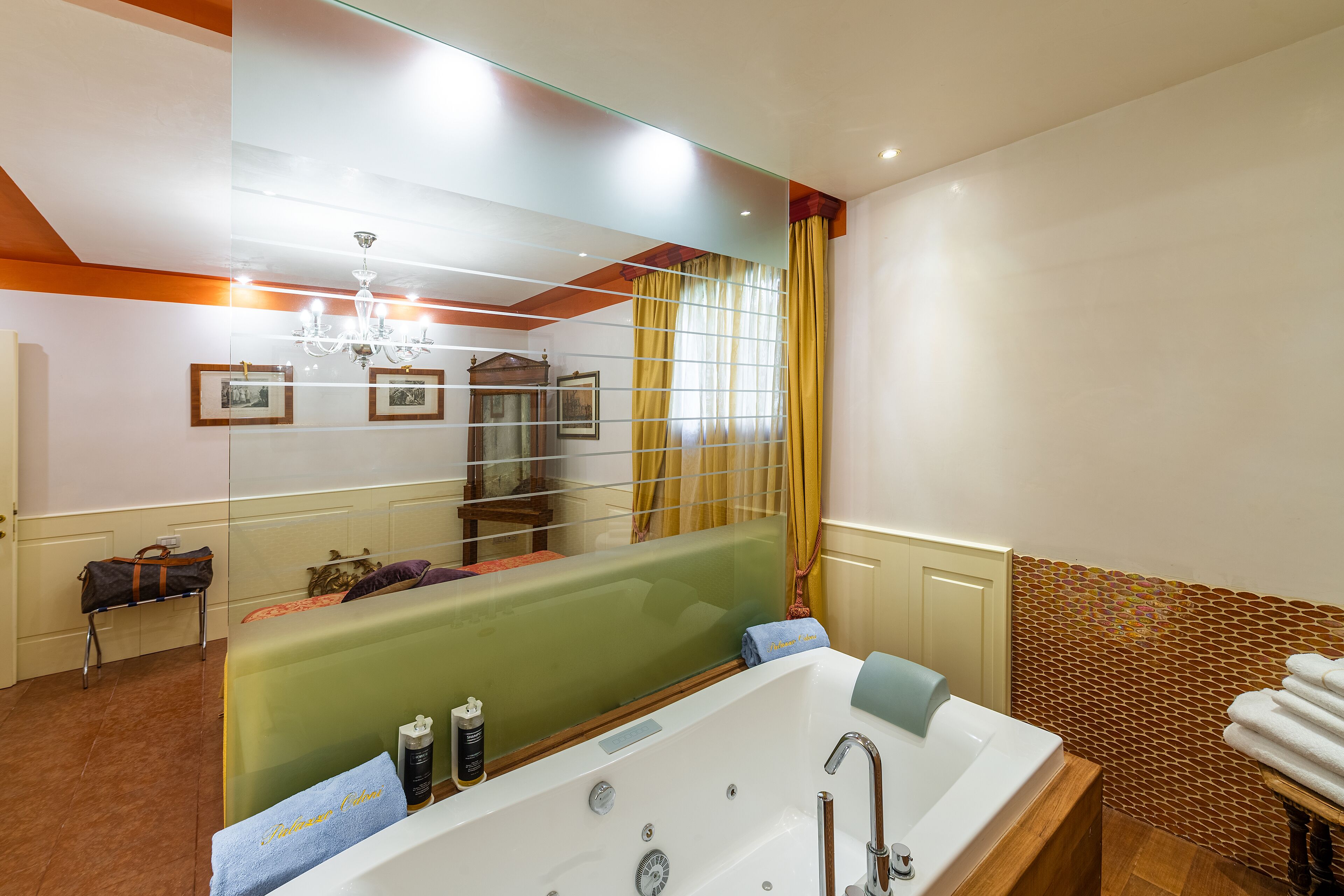Een moderne badkamer met een groot bad, een douchecabine van glas en een spiegel die de ruimte weerspiegelt.