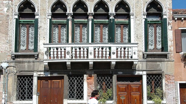 Un edificio histórico con ventanas arqueadas y un balcón.