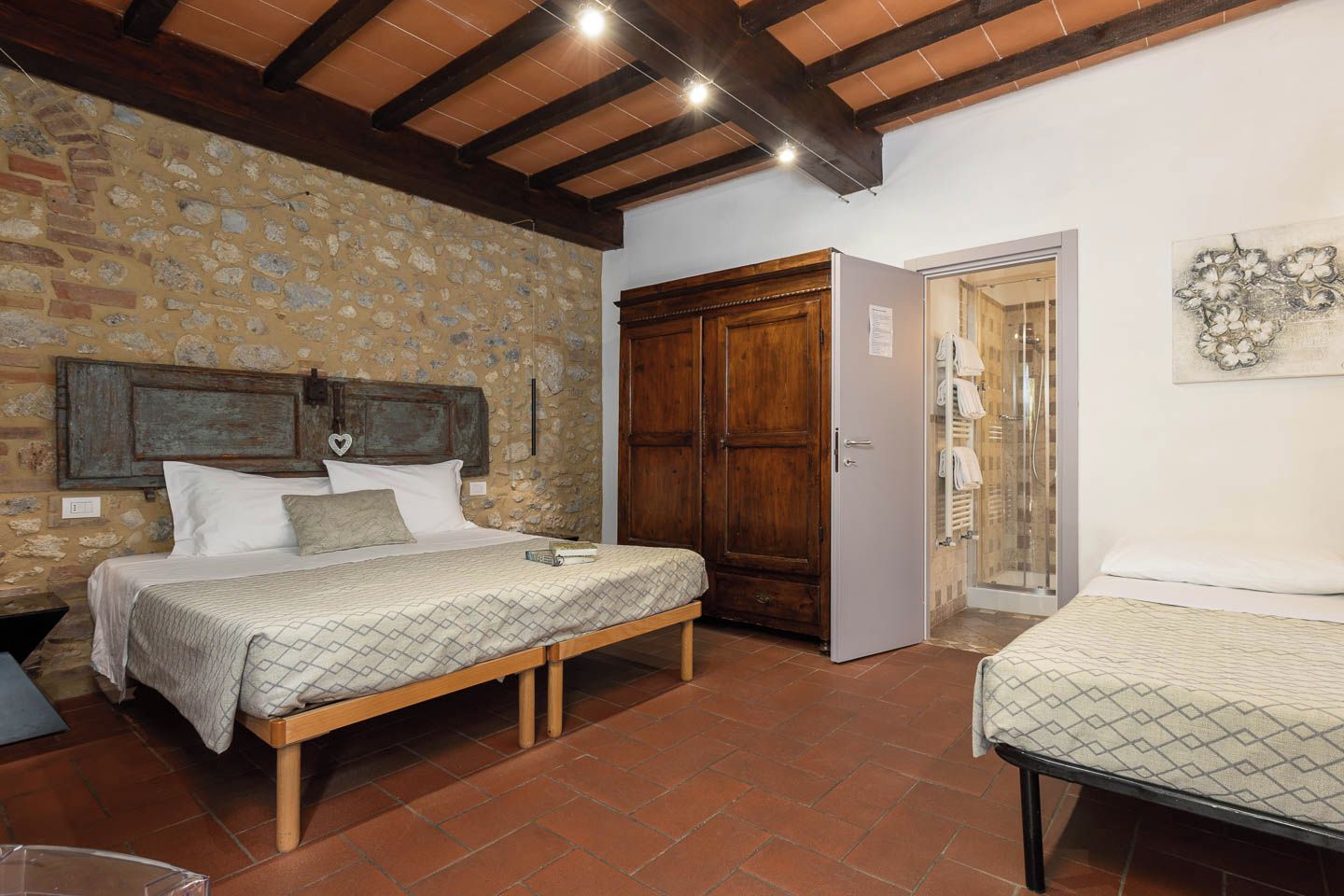 Una stanza con un letto, un armadio e un angolo doccia.