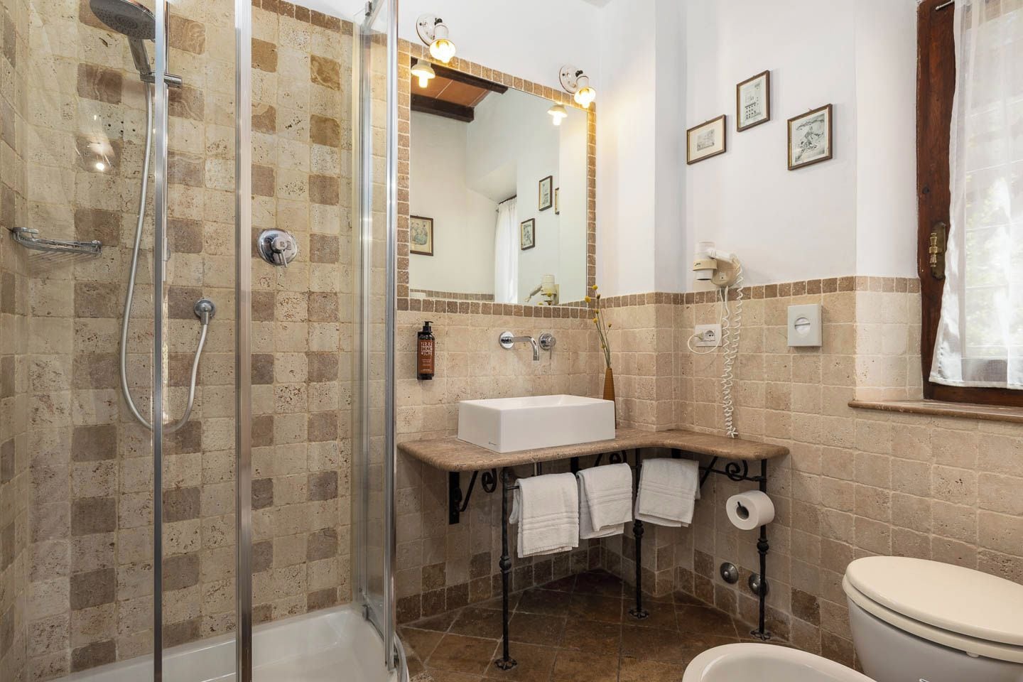 Een badkamer met douche, wastafel, toilet en spiegel.