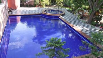 Alberca al aire libre y camastros