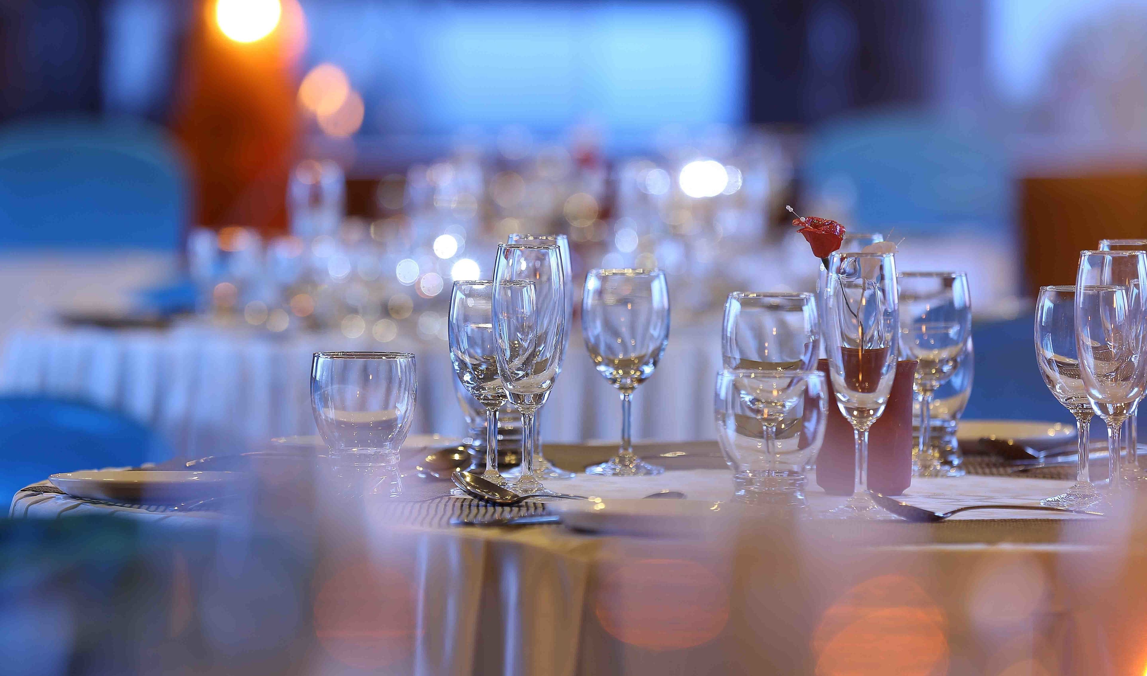 A table set for dining with multiple wine glasses and a water glass.