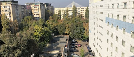 A multi-story parking garage with cars parked in rows, surrounded by trees and buildings.
