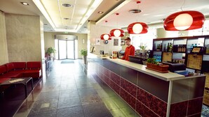 A hotel lobby with a reception desk, seating area, and potted plants. - Hello Hotels Bucharest (Bucharest)