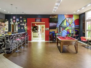 A billiards table, a pool table, and a bar area with stools. - Ibis Belem Aeroporto (Belém)