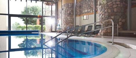 Una piscina techada, sillones reclinables de piscina