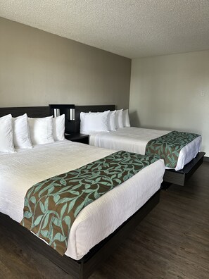 A hotel room with two beds, each with white bedding and a dark headboard. - Baymont by Wyndham Deming (Deming)