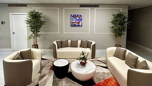 A modern living room with two sofas, a coffee table, and decorative plants. - Baymont by Wyndham Deming (Deming)
