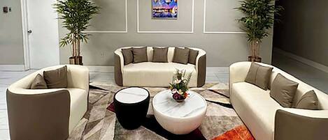 Una sala de estar moderna con dos sofás, una mesa de centro y plantas decorativas.