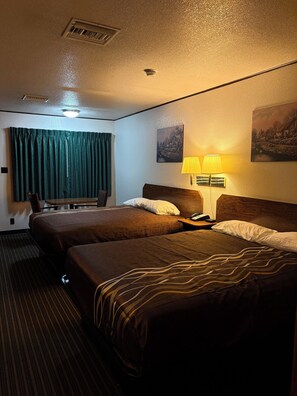 A hotel room with two beds, a desk, a chair, a lamp, and a painting on the wall. - Motel Garberville (Garberville)