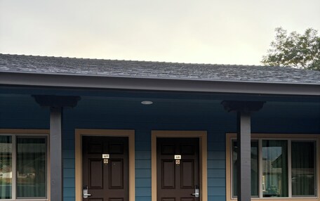 A two-story building with a blue exterior and brown doors.