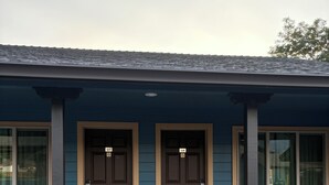 A two-story building with a blue exterior and brown doors.
