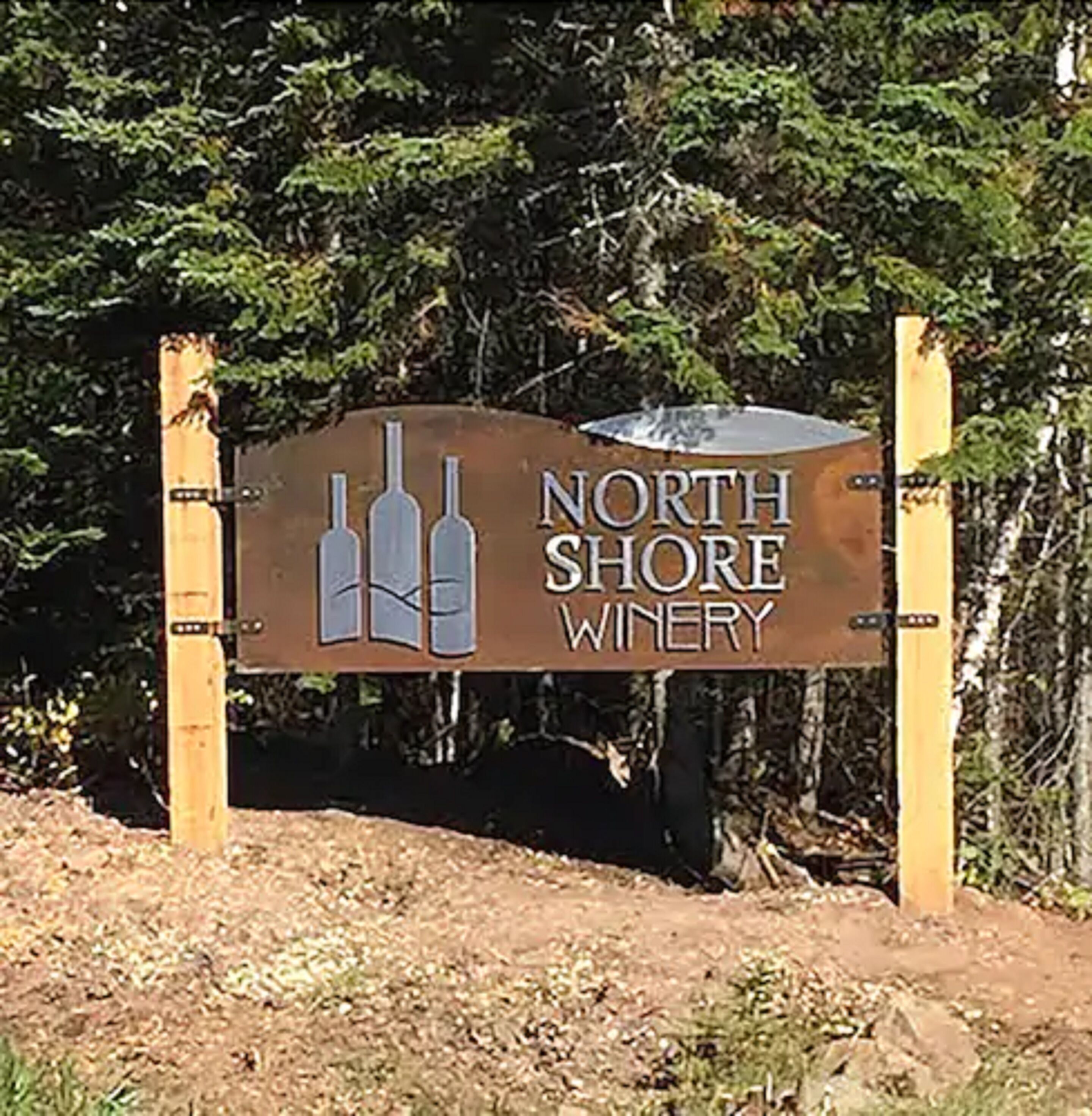 Un cartel para North Shore Winery con un logotipo de tres botellas de vino.