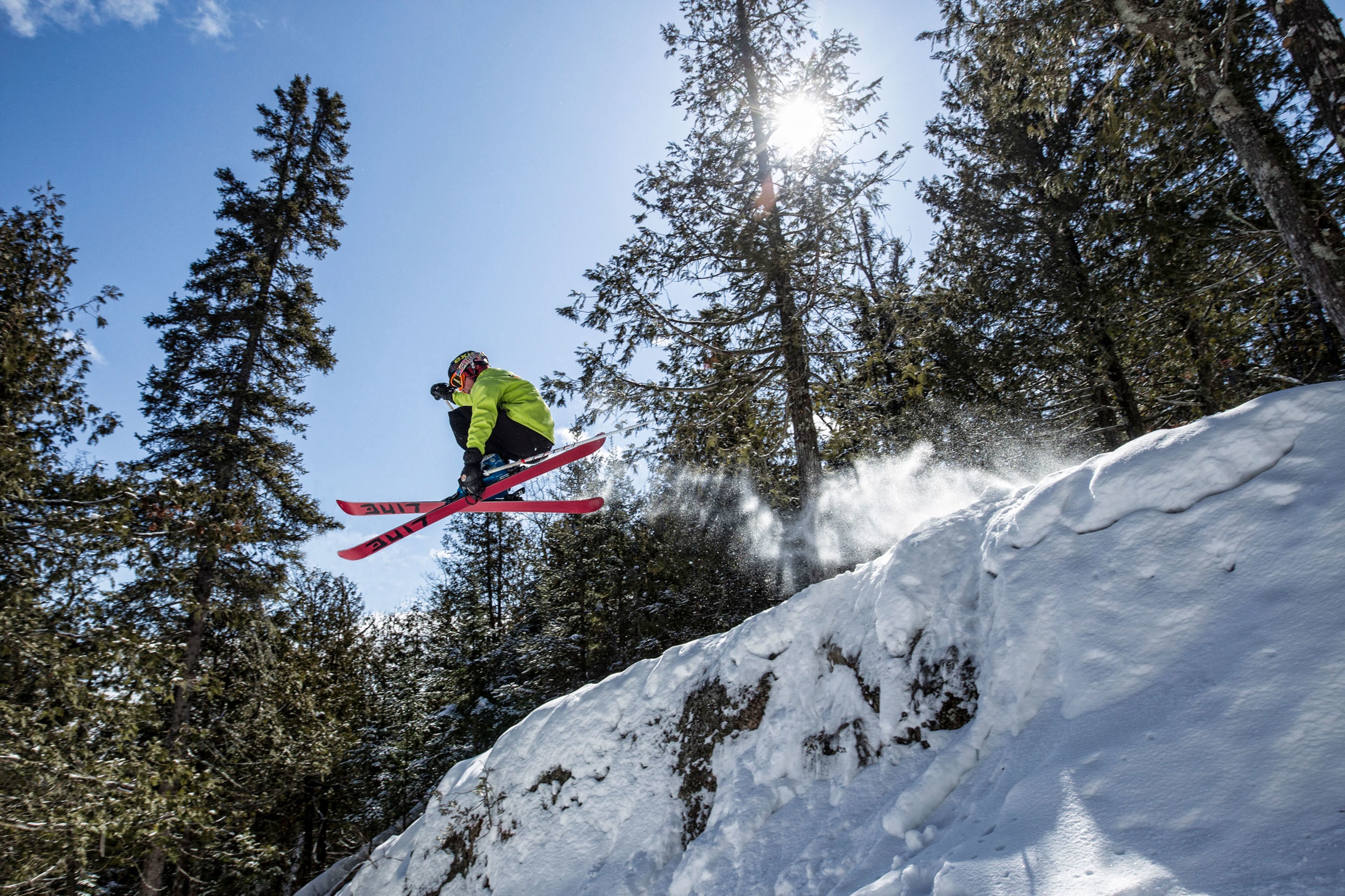 A person skiing on a snowy slope with trees in the background.