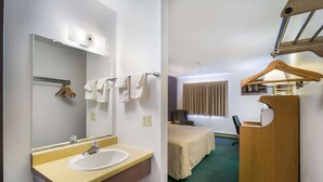 A hotel room with a bathroom featuring a sink, mirror, towel rack, and a wooden coat hook. The room includes a bed with a beige cover, a desk with a chair, and a coat rack. - The Roosevelt Hotel (Wibaux)