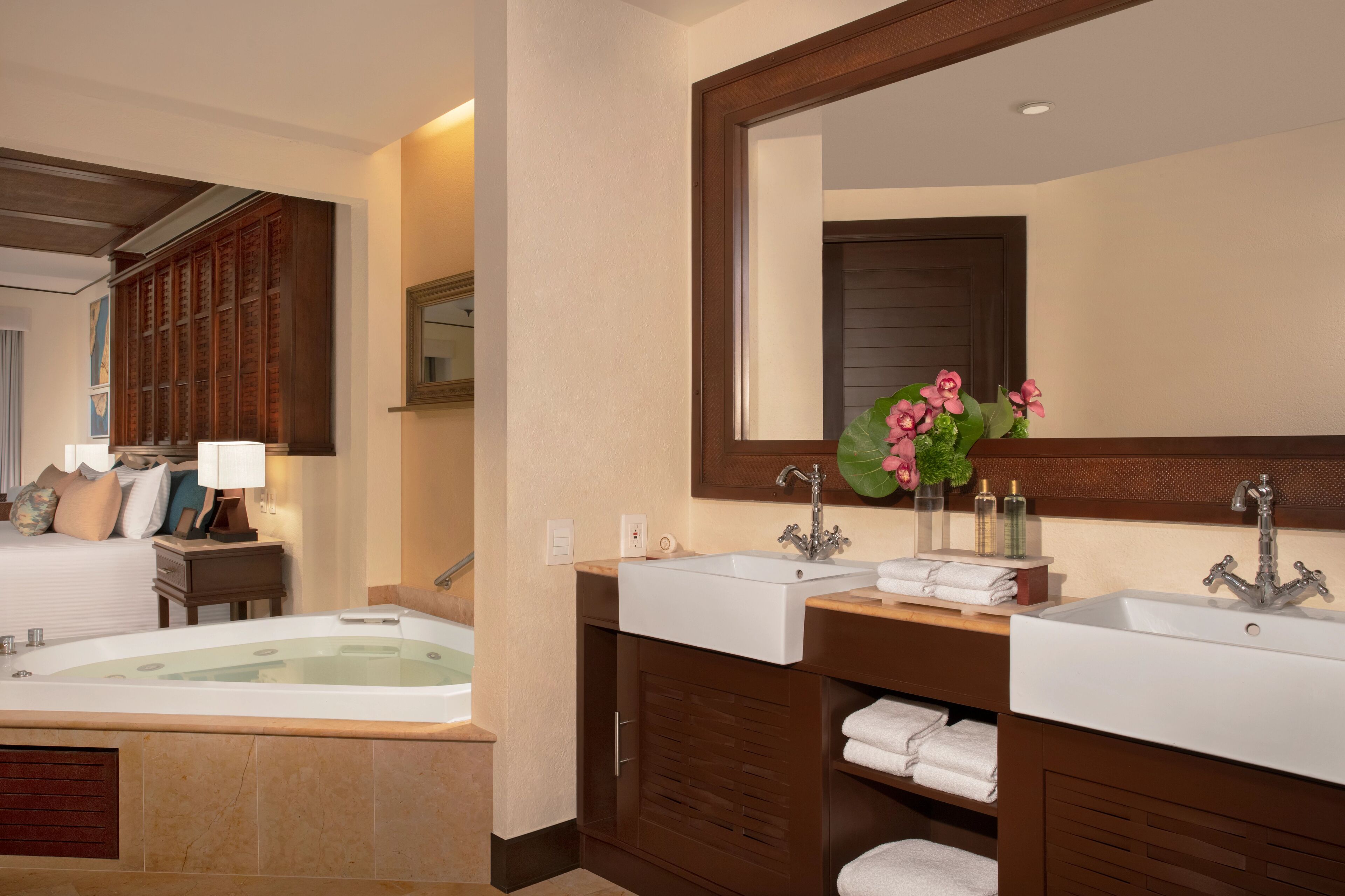Un baño moderno con una bañera grande, dos lavamanos y un espejo sobre el mueble-lavabo.