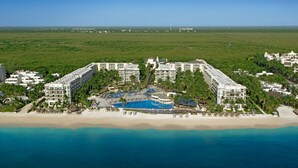 A resort with multiple buildings, a central pool, and a beach. - Dreams Riviera Cancun Resort & Spa - All Inclusive (Puerto Morelos)