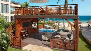 A resort with a pool area, outdoor seating, and a bar. - Dreams Riviera Cancun Resort & Spa - All Inclusive (Puerto Morelos)