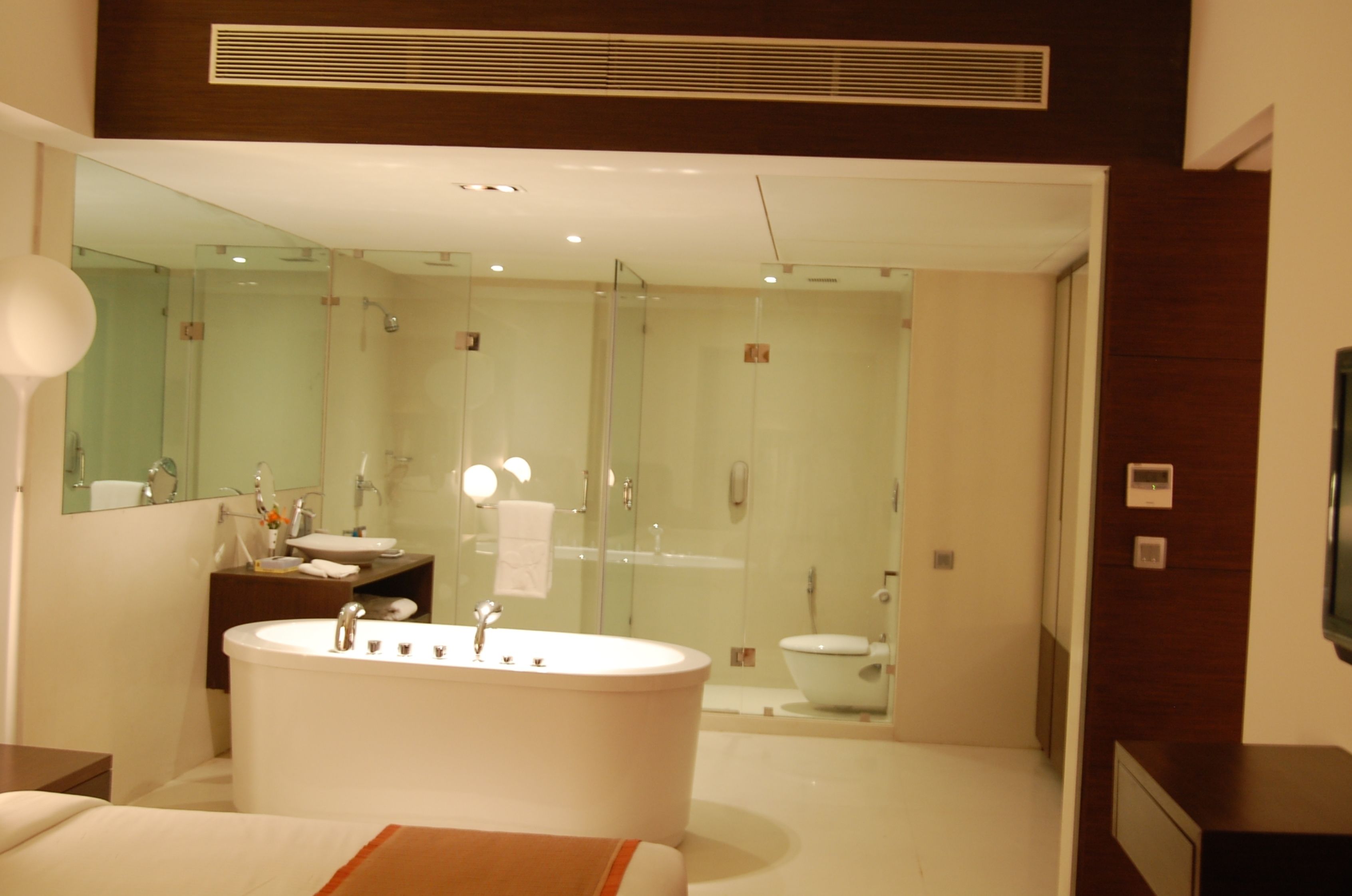 Un bany modern amb una banyera autònoma, dutxa amb envàs de vidre i un lavabo amb mirall.