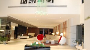 Eine geräumige Lobby mit Empfangstresen, Sitzgelegenheiten und einer Treppe.