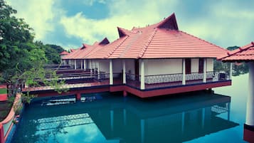 Traditional buildings with elevated views of a serene body of water, featuring balconies with outdoor space.